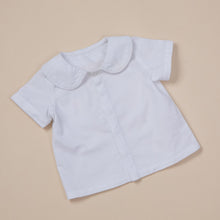Load image into Gallery viewer, white cotton short sleeve top with peter pan collar and piping for baby boy or toddler boy on beige background.