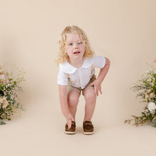 Load image into Gallery viewer, white cotton short sleeve top with peter pan collar and piping for baby boy or toddler boy on beige background.