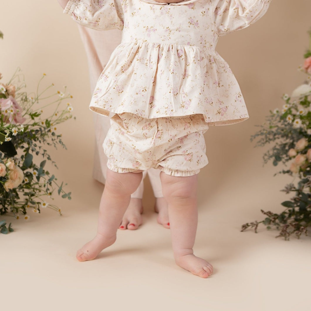 vintage rose print cotton bloomer for baby girl or toddler girl on beige background